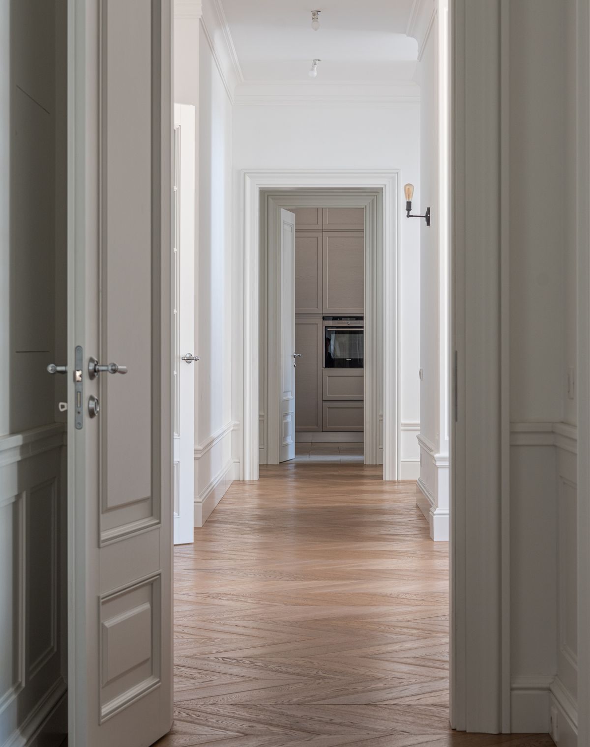 Hallway with finished door trim, baseboards, and crown molding